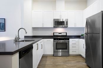 A kitchen with stainless steel appliances and white cabinets